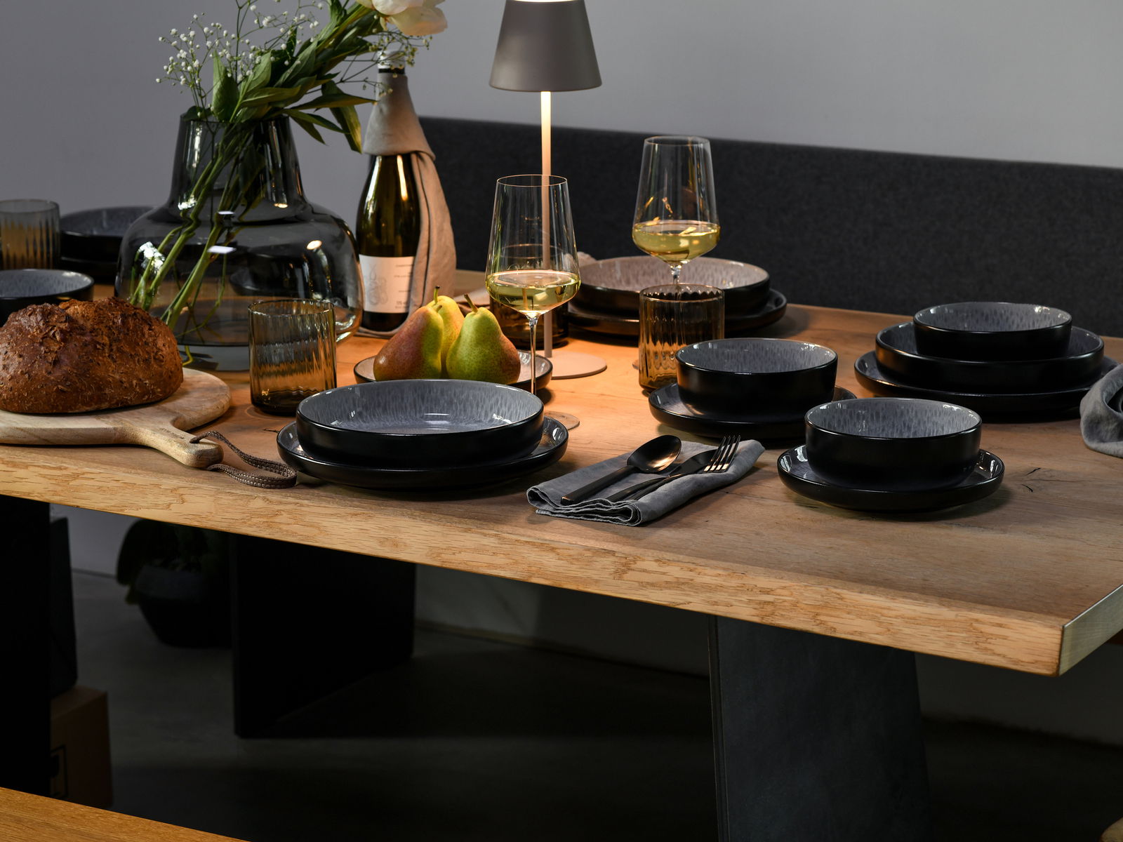 Creatable Kombiservice 30-tlg. Frost NORDIC FJORD Elegantes Kombiservice 30-tlg. Frost auf einem gedeckten Tisch, seitliche Perspektive, mit modernen schwarzen Tellern und Schalen, umgeben von stilvollen Gläsern, Besteck und Dekoration.