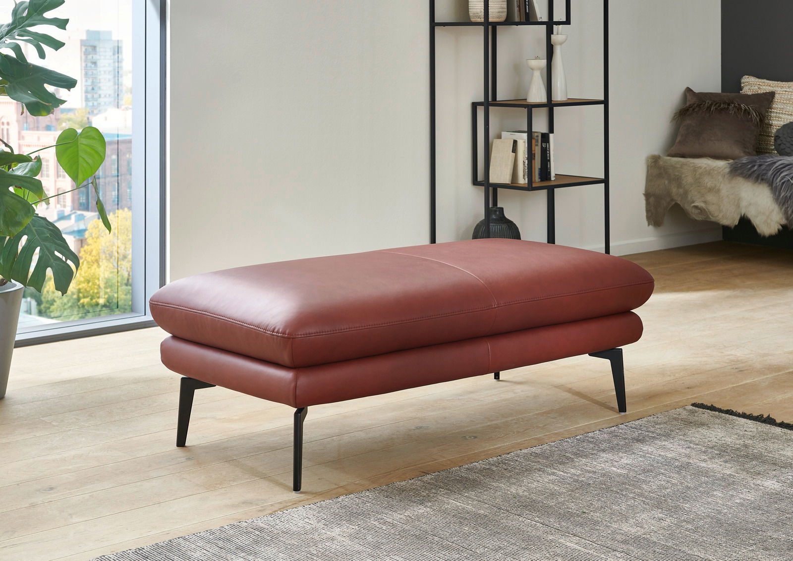 Dieter Knoll XXL-Hocker ARZONA L Roter XXL-Hocker aus Leder mit schwarzen Metallbeinen, seitliche Perspektive in modernem Wohnzimmer