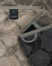 Nahaufnahme eines luxuriösen Duschtuchs mit elegantem Muster und JOOP!-Label, in einer diagonalen Perspektive.