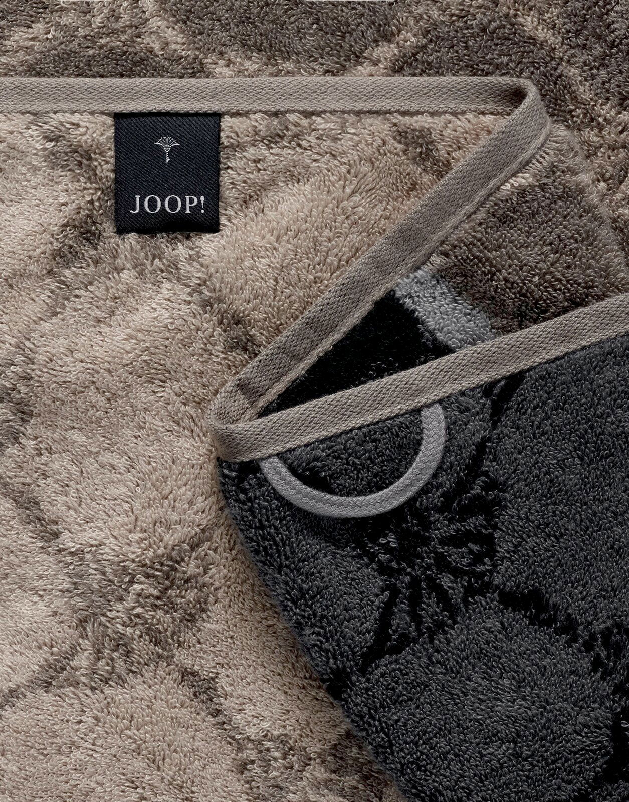 Nahaufnahme eines luxuriösen Duschtuchs mit elegantem Muster und JOOP!-Label, in einer diagonalen Perspektive.