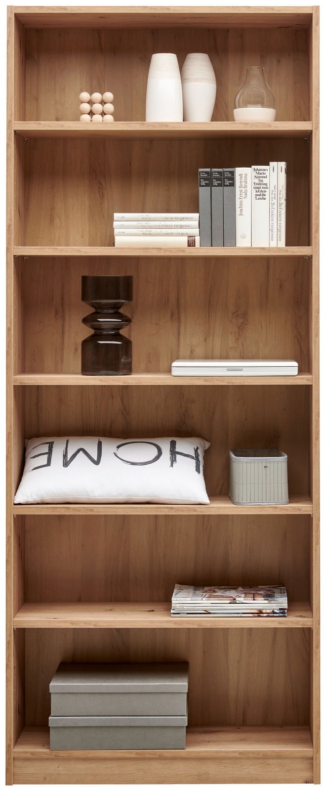 Holzregal mit mehreren Fächern, gefüllt mit Büchern, Dekorationsgegenständen und Kissen, frontal betrachtet.