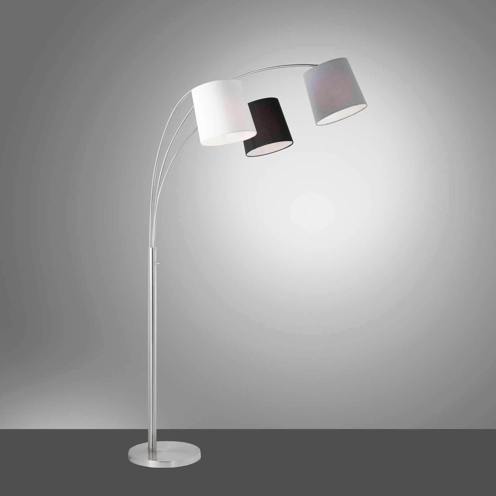 Moderne Stehleuchte aus Stahl mit drei gebogenen Armen und unterschiedlich farbigen Lampenschirmen in Weiß, Schwarz und Grau, seitliche Perspektive.