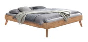 Modern houten bed met schuine poten en grijs beddengoed en deken, vrijstaand op een witte achtergrond, schuin van voren/opzij gezien.