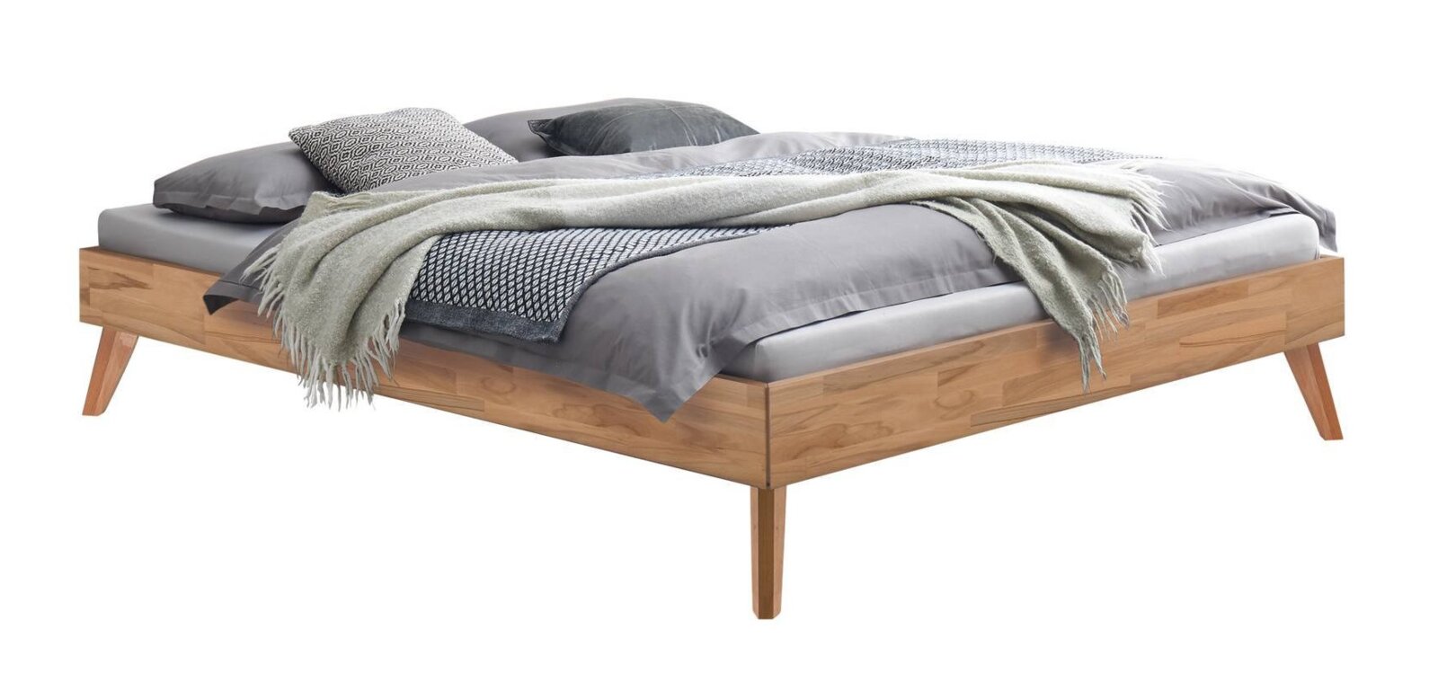 Modern houten bed met schuine poten en grijs beddengoed en deken, vrijstaand op een witte achtergrond, schuin van voren/opzij gezien.