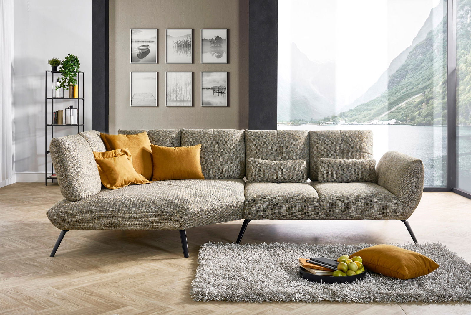 Moderne Rundecke in einem stilvollen Wohnzimmer mit Blick auf ein großes Fenster, das eine malerische Landschaft zeigt. Die Couch ist mit gelben Kissen dekoriert und steht auf einem hellen Holzboden neben einem flauschigen Teppich.