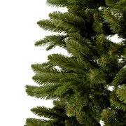 Close-up van groene dennentakken van een kunstkerstboom, gezien vanuit de zijkant.