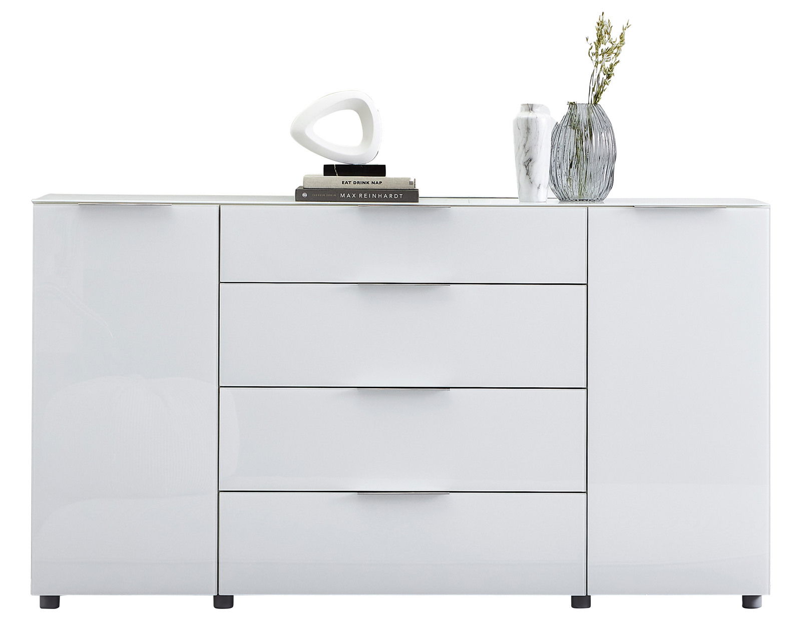 Weißes Sideboard mit vier Schubladen und zwei Türen, dekoriert mit Büchern, einer modernen Skulptur und Vasen, frontale Ansicht.