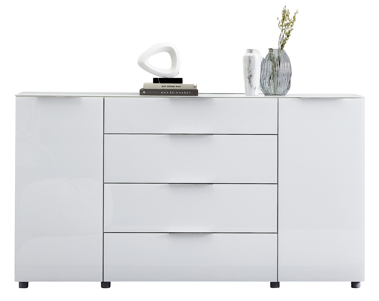 Weißes Sideboard mit vier Schubladen und zwei Türen, dekoriert mit Büchern, einer modernen Skulptur und Vasen, frontale Ansicht.