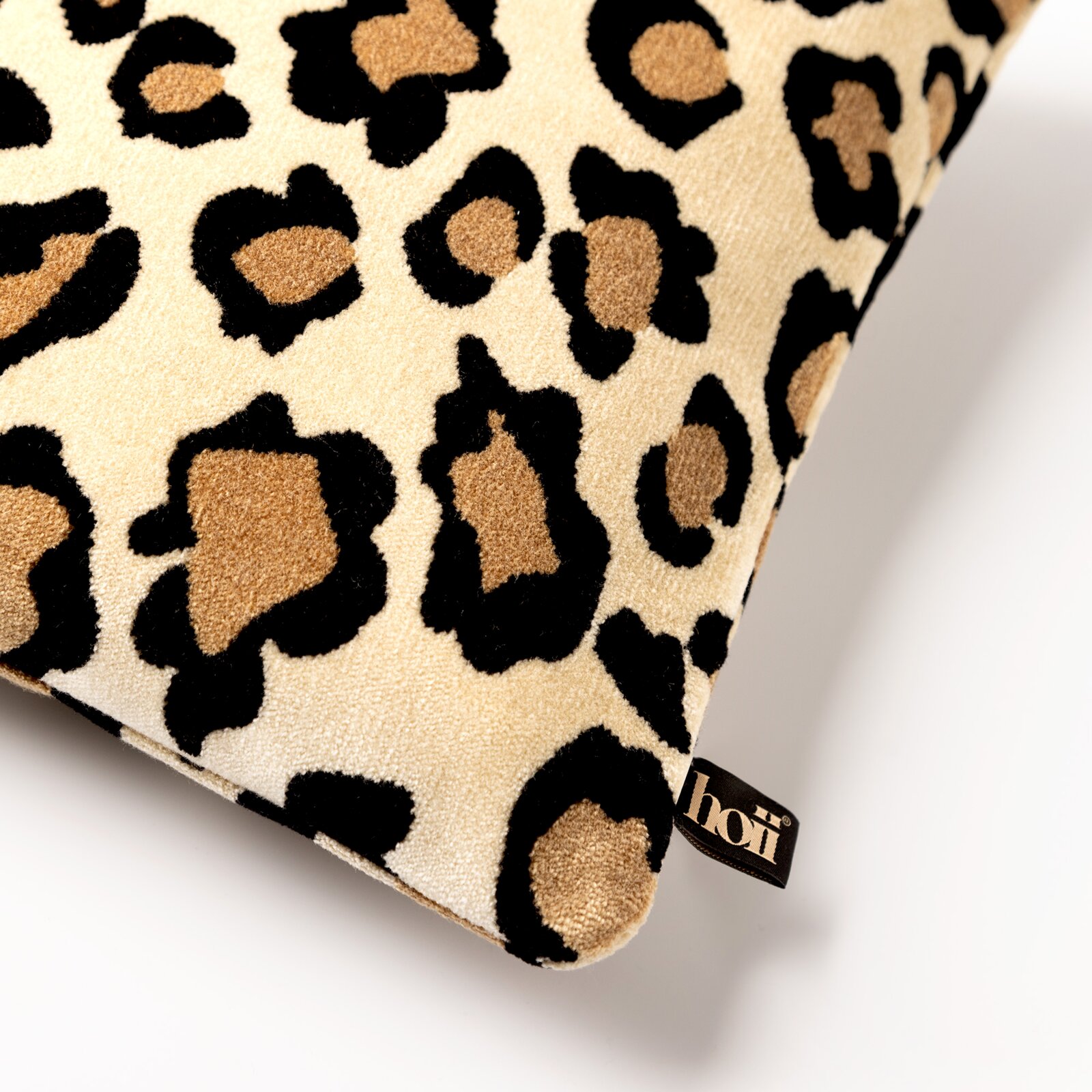 Sierkussen met luipaardprint, close-up van de hoek met het merklabel