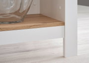 Detailfoto van een kookeiland met een wit frame en een houten werkblad, in perspectief vanaf de zijkant gefotografeerd.