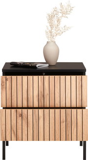 Nachtkommode mit Holzfronten und schwarzer Ablage, dekoriert mit einer Vase und Zweigen, Frontalansicht