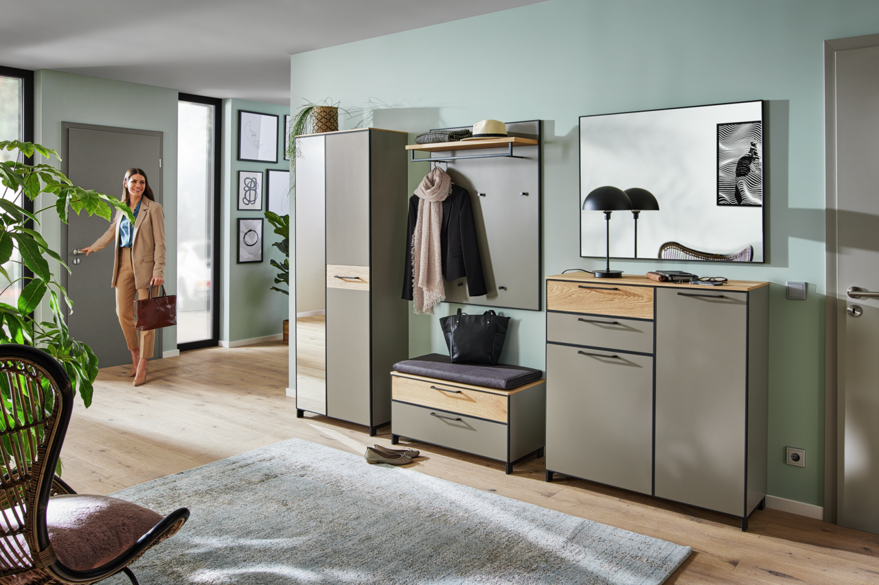 Moderne Garderobeneinrichtung mit Schuhschrank, Garderobenbank, Spiegel und Paneel in einem hellen Flur. Perspektive von vorne.