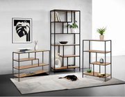 Drie moderne rekken in verschillende afmetingen met een zwart metalen frame en houten planken, gefotografeerd in een stijlvolle woonkamer met decoraties en een slapende hond op een tapijt.