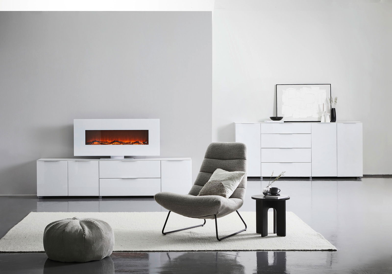 Modernes XL-Sideboard in Weiß mit Hochglanzoberfläche, zentral im Raum platziert, mit dekorativem Elektrokamin auf der linken Seite und stilvollen Accessoires auf der rechten Seite.