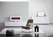 Modernes XL-Sideboard in Weiß mit Hochglanzoberfläche, zentral im Raum platziert, mit dekorativem Elektrokamin auf der linken Seite und stilvollen Accessoires auf der rechten Seite.