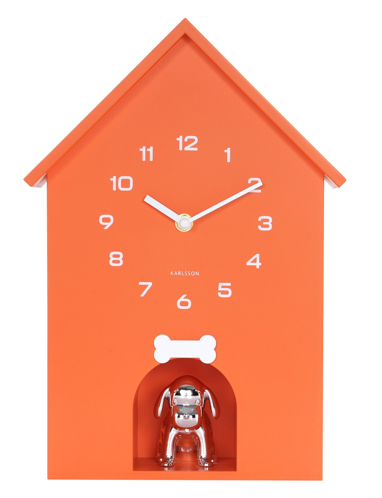 Orangefarbene Wanduhr in Form eines Hauses mit weißen Ziffern und Zeigern, darunter eine silberne Hundefigur. Frontalansicht.