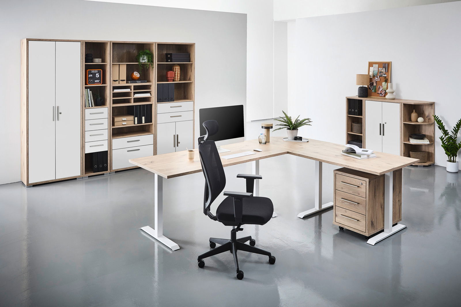 Moderne Büroumgebung mit L-förmigem Schreibtisch, ergonomischem Bürostuhl und mehreren Regalen in Holzoptik. Perspektive von vorne.