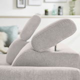 Nahaufnahme eines hellgrauen Ecksofas mit verstellbarer Kopfstütze, seitliche Perspektive.