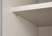 Nahaufnahme eines Einlegebodens in einem Schwebetürenschrank, montiert mit Metallhalterungen. Perspektive von unten links.