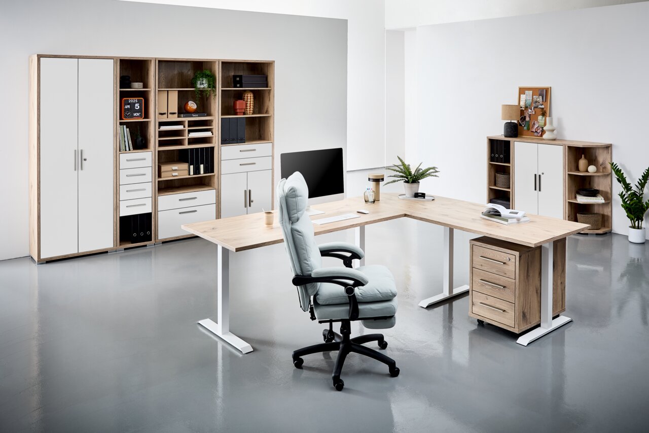 Moderne Büroumgebung mit L-förmigem Schreibtisch, ergonomischem Bürostuhl und Regalsystemen in Holzoptik, aus der Perspektive von vorne rechts betrachtet.