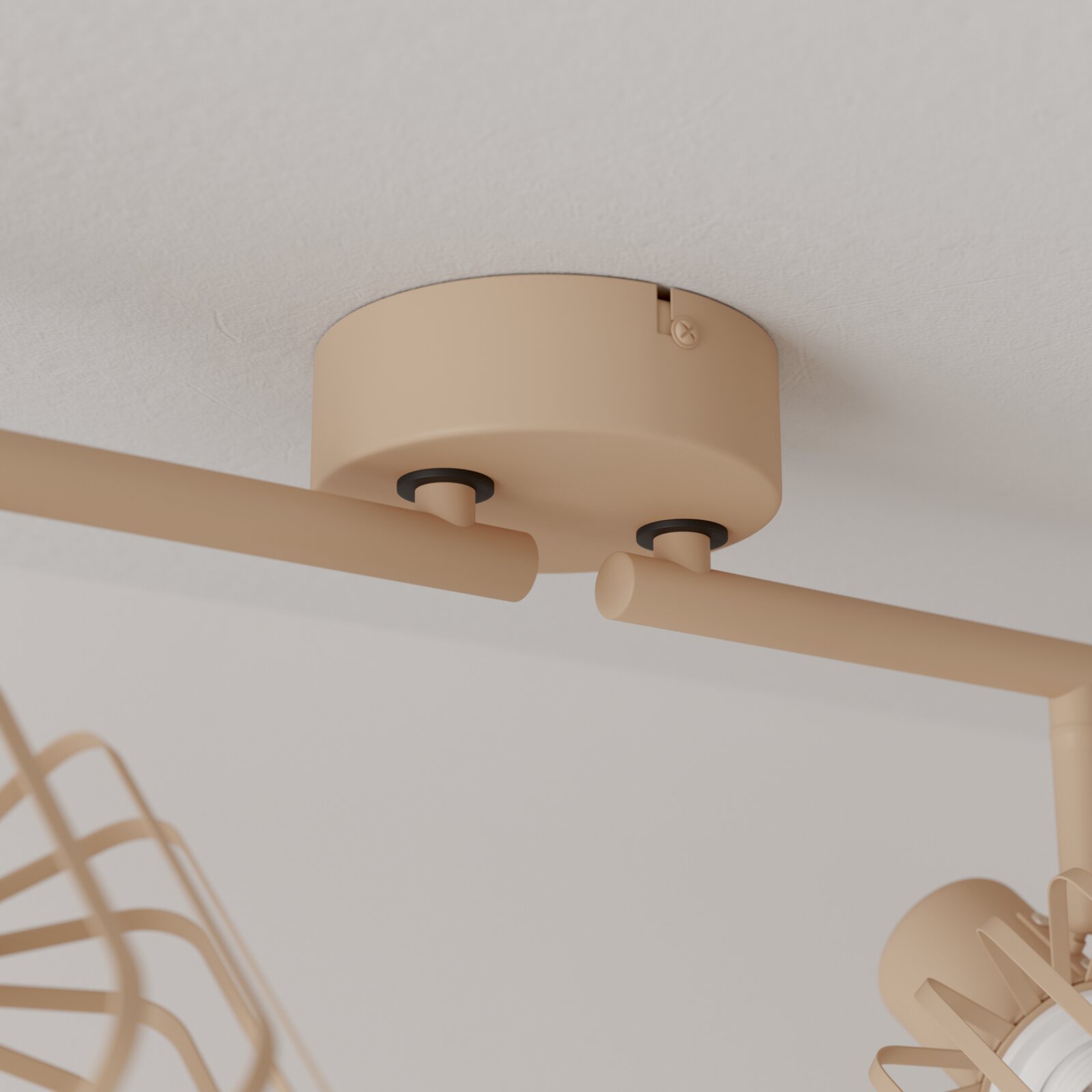 Beige Deckenleuchte mit zwei zylindrischen Spots an runder Deckenhalterung, Ansicht von unten in leichter Untersicht.