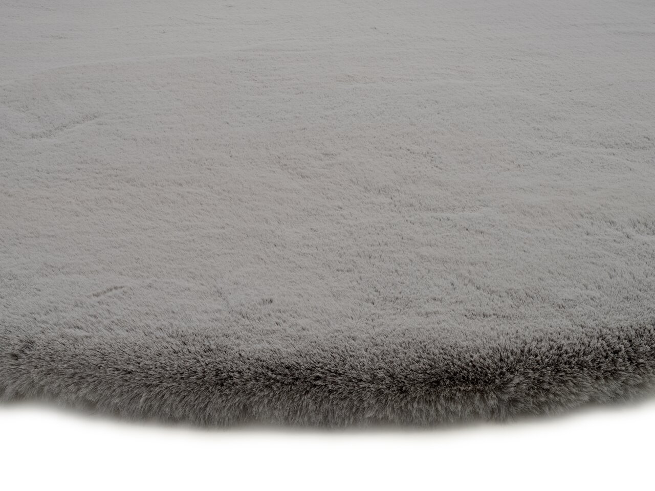 Grauer Fellteppich in Nahaufnahme, flauschige Textur, seitliche Perspektive