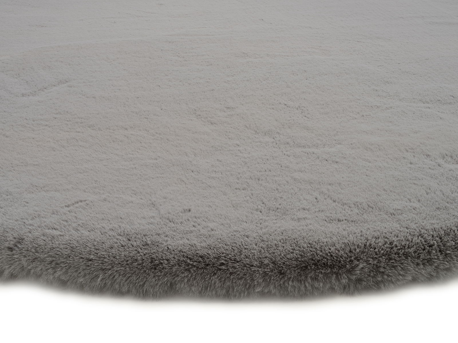Grauer Fellteppich in Nahaufnahme, flauschige Textur, seitliche Perspektive