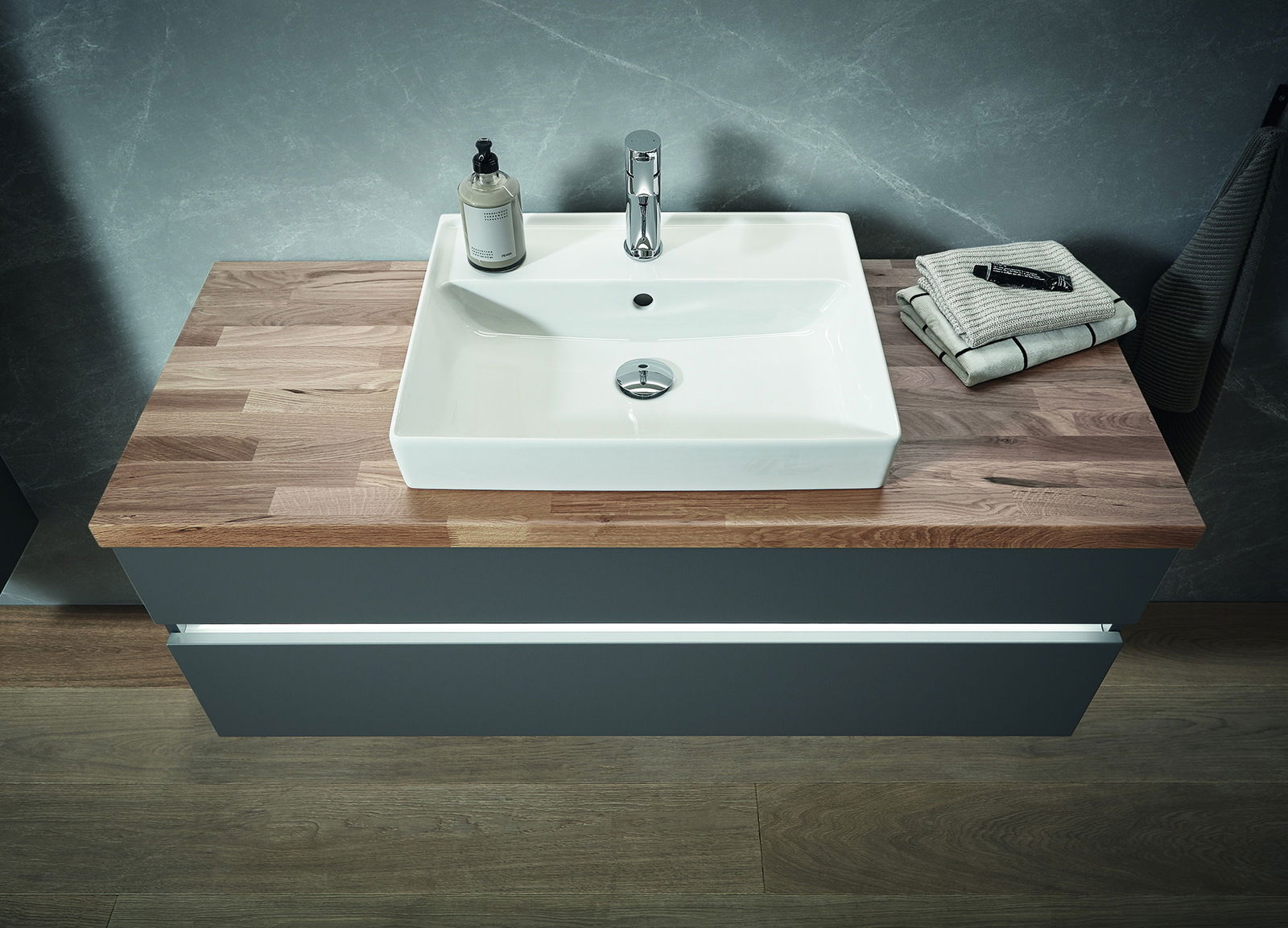 Moderne Badkombination mit rechteckigem Waschbecken auf Holzplatte, von oben betrachtet.