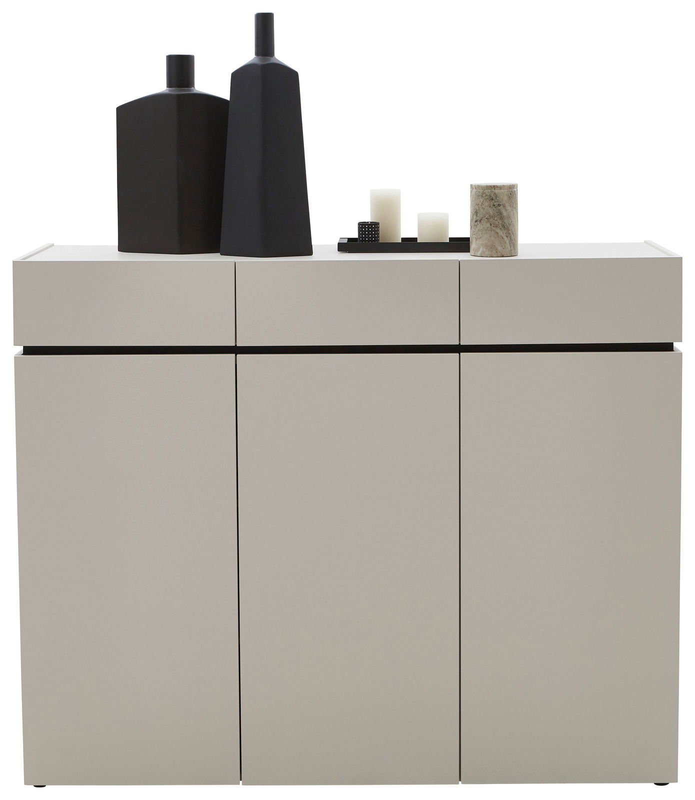 Moderne breite Kommode in hellem Grau mit drei Türen, dekoriert mit schwarzen Vasen und Kerzen, Frontalansicht