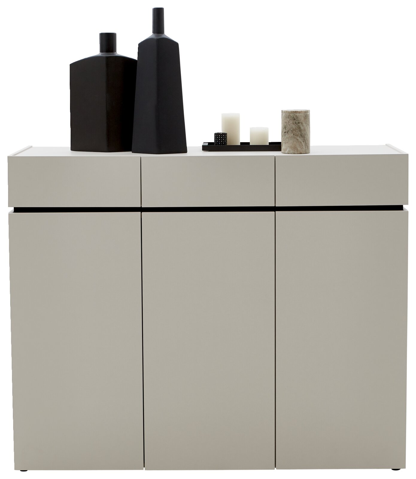 Moderne breite Kommode in hellem Grau mit drei Türen, dekoriert mit schwarzen Vasen und Kerzen, Frontalansicht