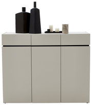 Moderne breite Kommode in hellem Grau mit drei Türen, dekoriert mit schwarzen Vasen und Kerzen, Frontalansicht