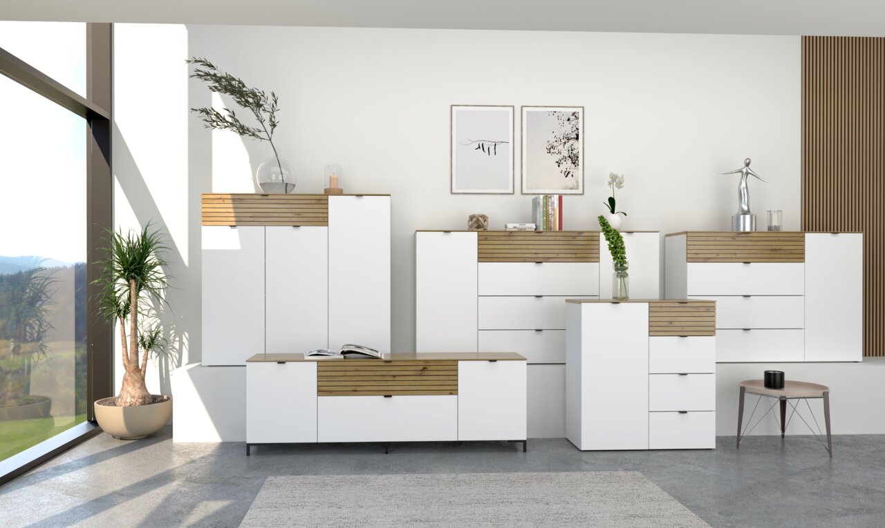Voleo Sideboard DIANA Moderne Garderobenmöbel in Weiß mit Holzdetails, bestehend aus Schränken und Kommoden, in einem hellen Raum mit großen Fenstern. Frontalansicht.