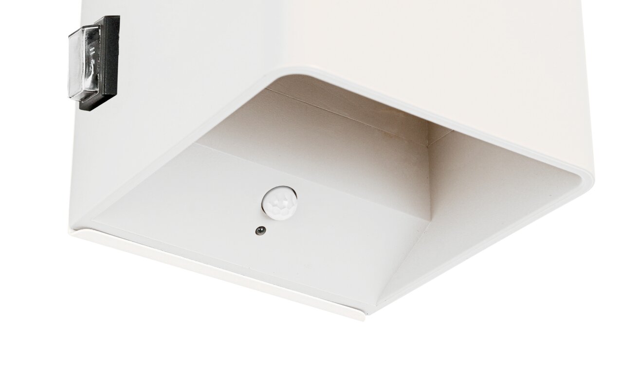 Close-up van een witte wandlamp op accu met bewegingssensor, gezien van onderaf.