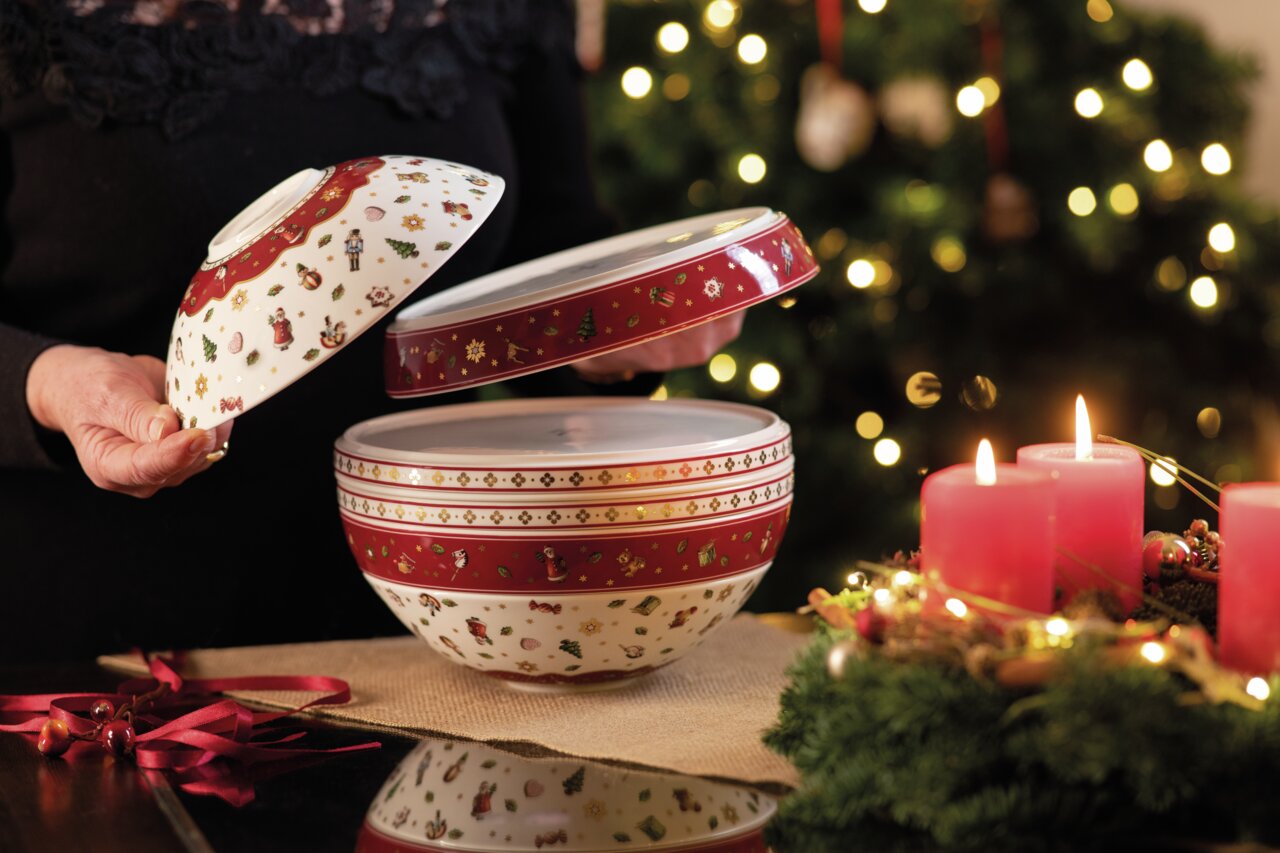 Villeroy & Boch La Boule Weihnachtlich dekorierte Schüssel 'La Boule' mit abnehmbarem Deckel, umgeben von festlicher Beleuchtung und Kerzen, seitliche Perspektive.