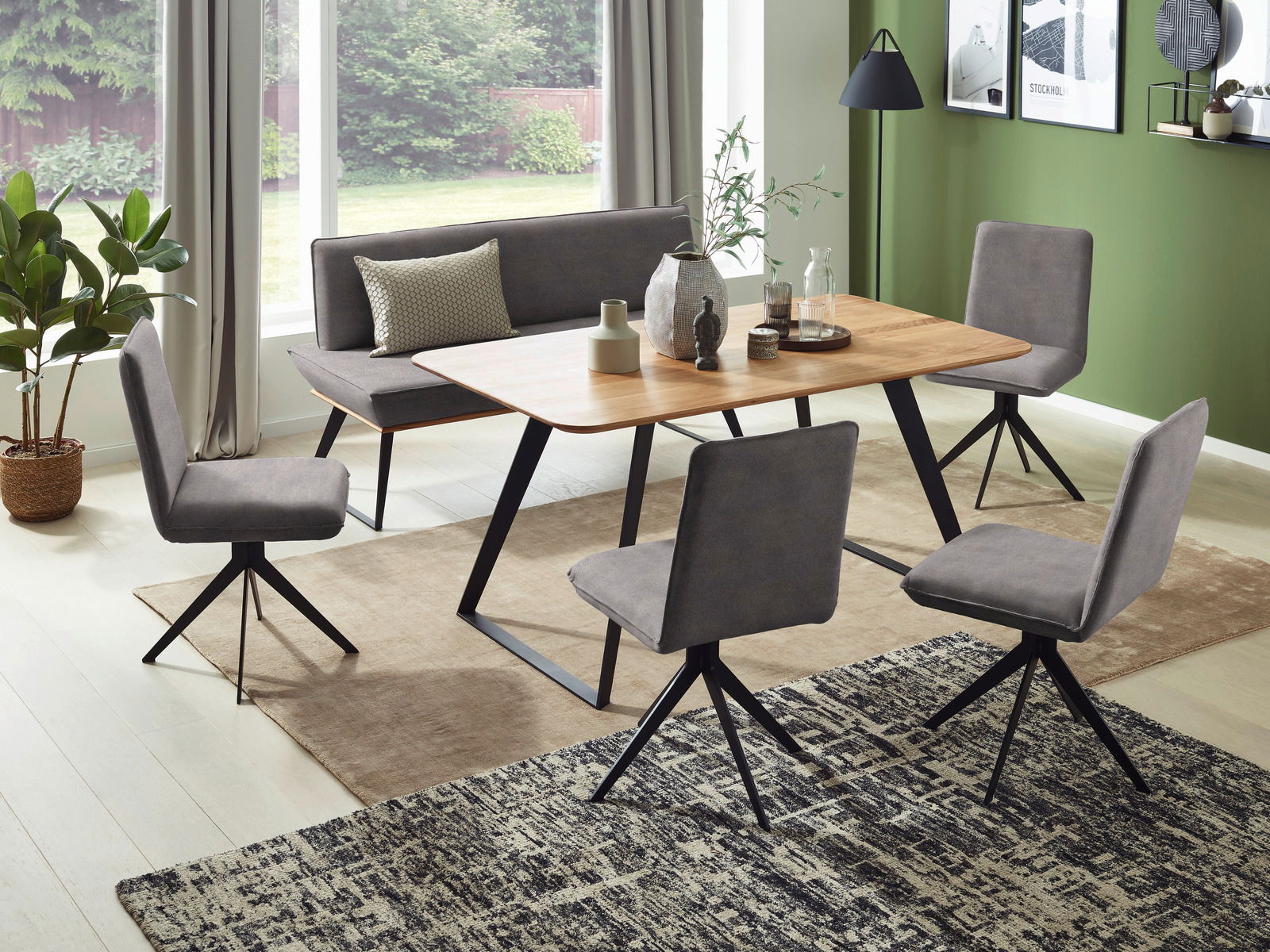 Esszimmer mit modernem Tisch und Bank in Holzoptik, umgeben von grauen Stühlen. Die Perspektive zeigt den Raum von schräg oben.