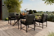 Een moderne tuinstoel op een terras met uitzicht op het landschap, omringd door een stijlvolle eettafelset.