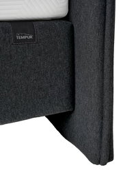Nahaufnahme eines grauen Boxspringbetts mit TEMPUR-Logo, seitliche Perspektive