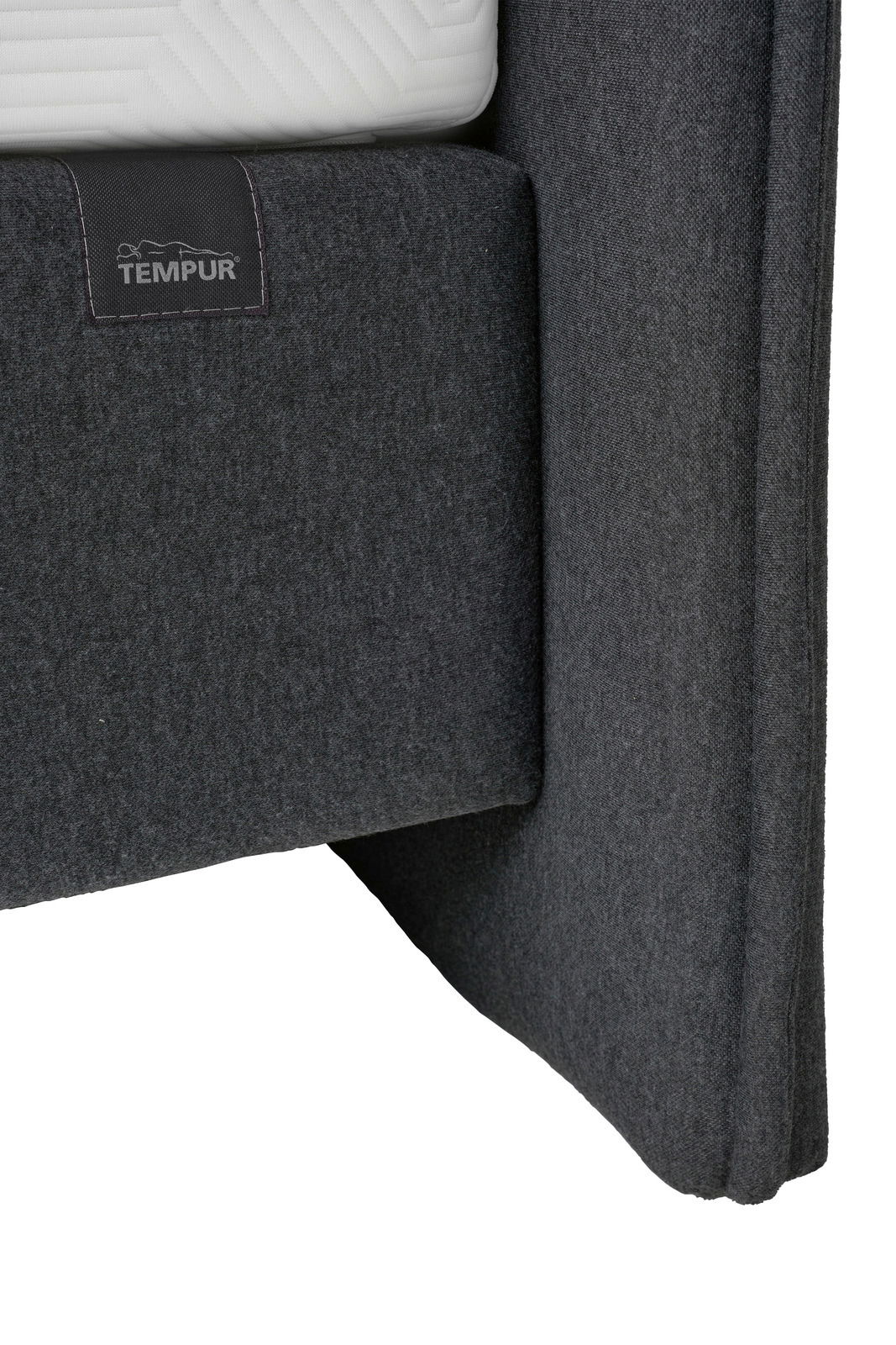 Nahaufnahme eines grauen Boxspringbetts mit TEMPUR-Logo, seitliche Perspektive