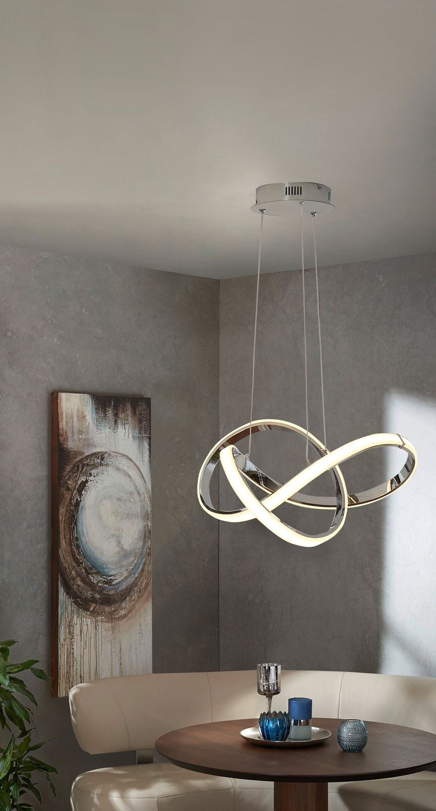 Moderne LED-Hängeleuchte in geschwungenem Design, von unten betrachtet, über einem Esstisch in einem stilvoll eingerichteten Raum.