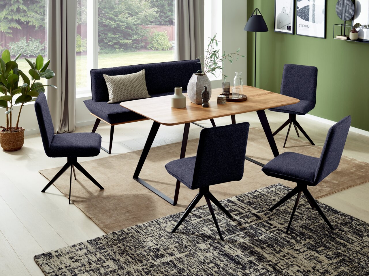 Esszimmer mit modernem Tisch und vier dunkelblauen Stühlen, seitliche Perspektive