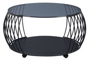 Moderner Couchtisch mit rundem Glasplatte und schwarzem Metallgestell, seitliche Perspektive.