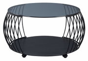 Moderne salontafel met rond glazen blad en zwart metalen onderstel, gezien vanaf de zijkant.