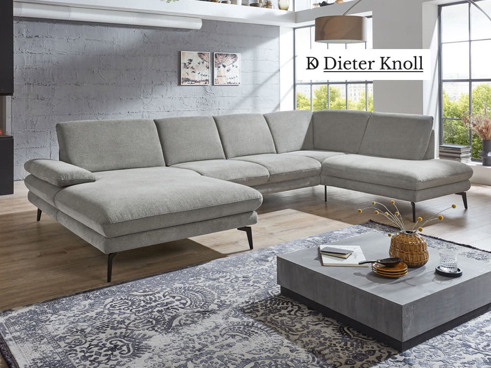 Modernes Dieter Knoll Wohnzimmer mit großer grauer Eckcouch, Beton-Couchtisch und Loft-Ambiente.