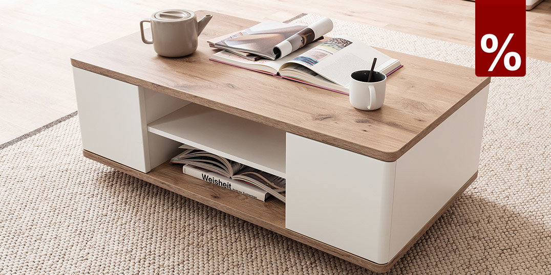 Moderner Couchtisch in Holzoptik mit weißen Elementen, Deko und Tasse auf hellem Teppich im Wohnzimmer.