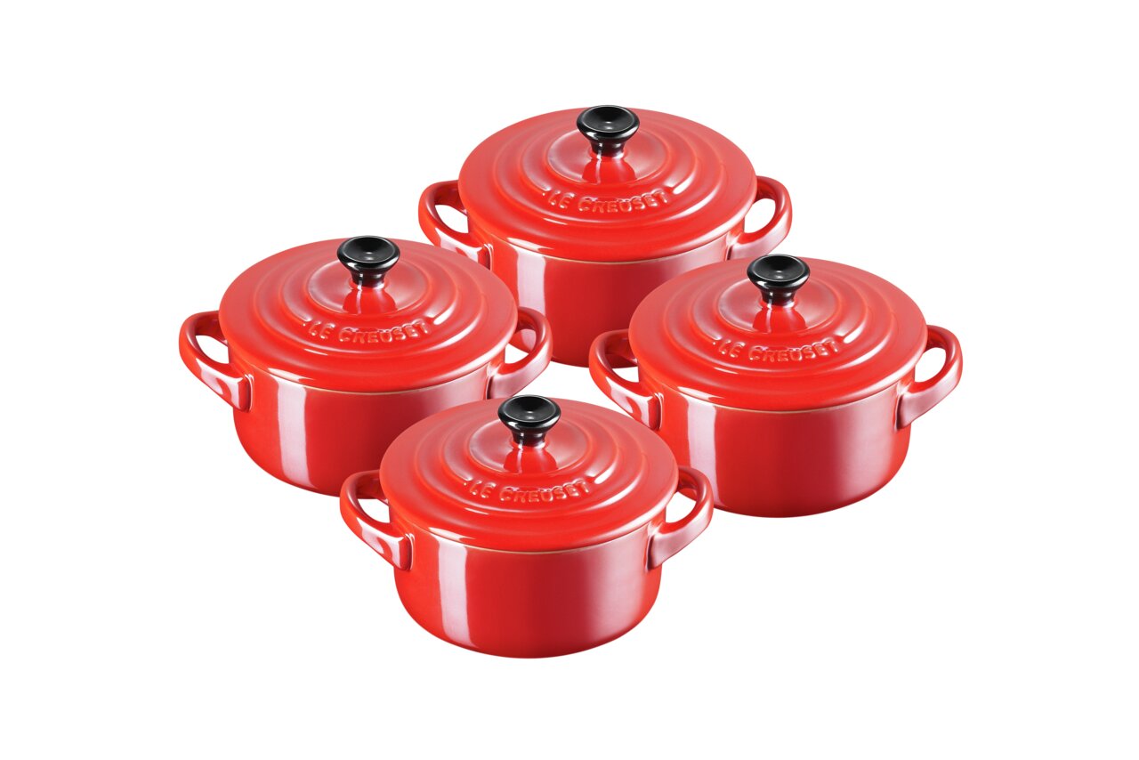LE CREUSET Mini-Cocotte 4er-Set 10cm Metallics Kirschrot Vier rote Mini Cocottes aus Metall, von oben betrachtet, mit schwarzen Knöpfen auf den Deckeln.