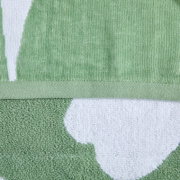 Detailaufnahme aus frontaler Perspektive: grün-weißes Frotteehandtuch mit eingewebtem Muster und gesäumter Kante