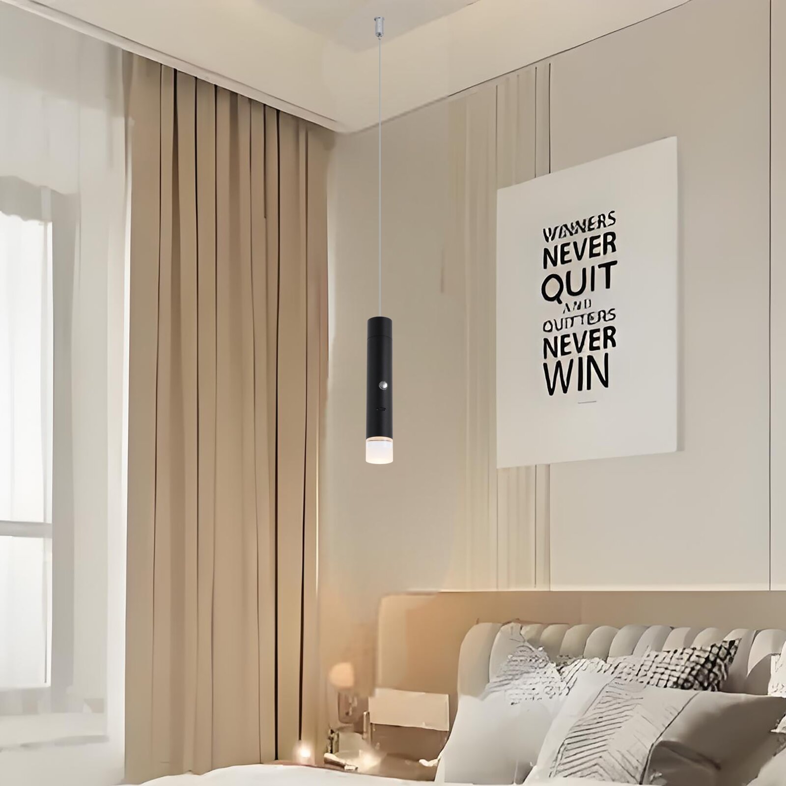 Schwarze zylindrische LED-Pendelleuchte mit schlankem Kabel und satiniertem Diffusor, von vorn leicht seitlich in einem modernen Schlafzimmer hängend über dem Bett