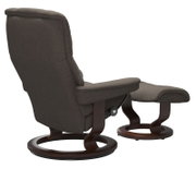 Achterkant van een Stressless-set bestaande uit een eenpersoonsfauteuil RENO met voetenbank, donkerbruine stoffen bekleding en houten frame.