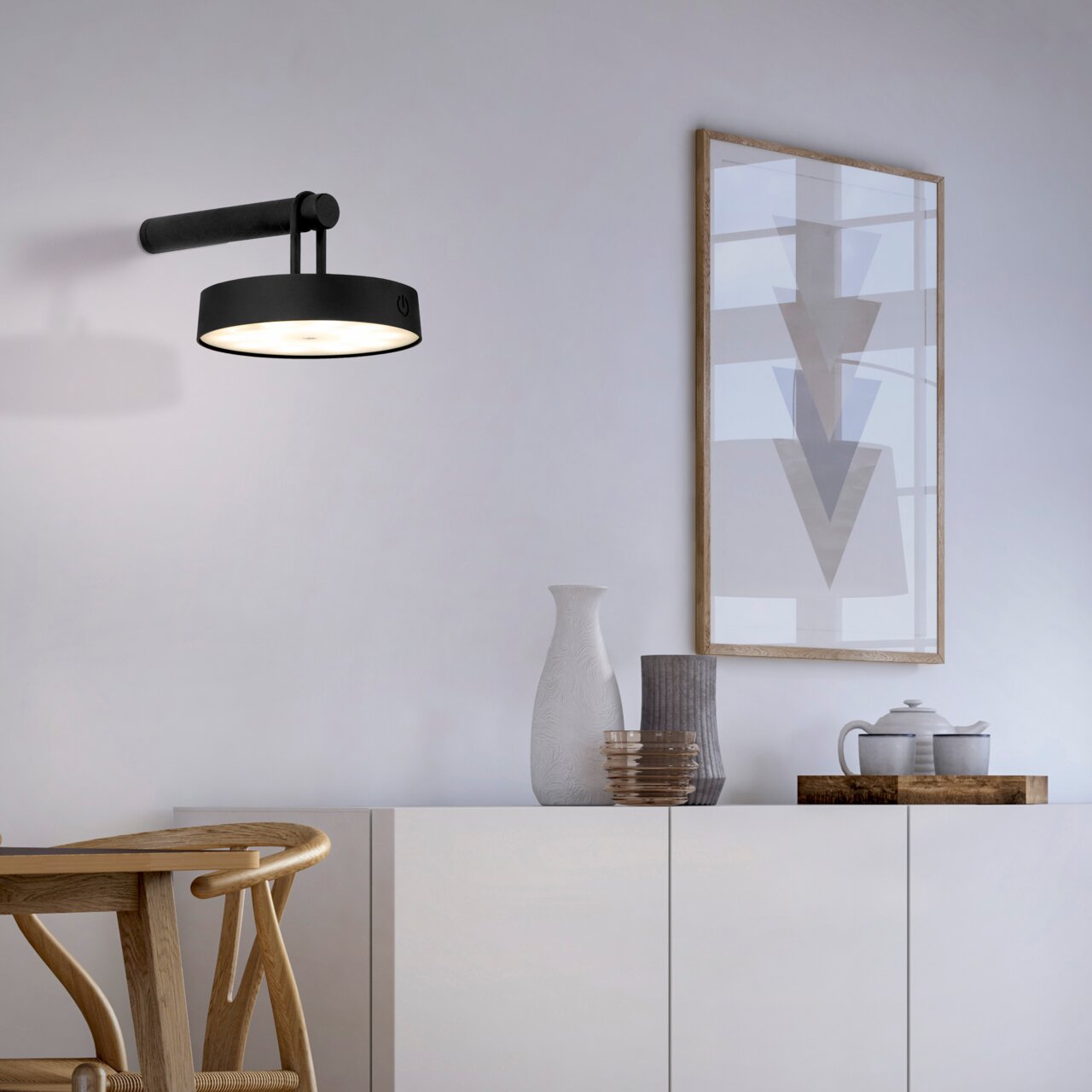 Moderne schwarze Wandleuchte ARMA in einem stilvollen Wohnzimmer, seitliche Perspektive.