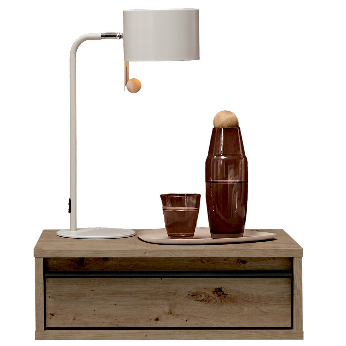 Weiße Tischlampe mit zylindrischem Schirm und Holz-Zugknopf auf einem Holz-Nachttisch, daneben braune Glasflasche und Glas auf Tablett, frontal aus leicht erhöhter Perspektive.